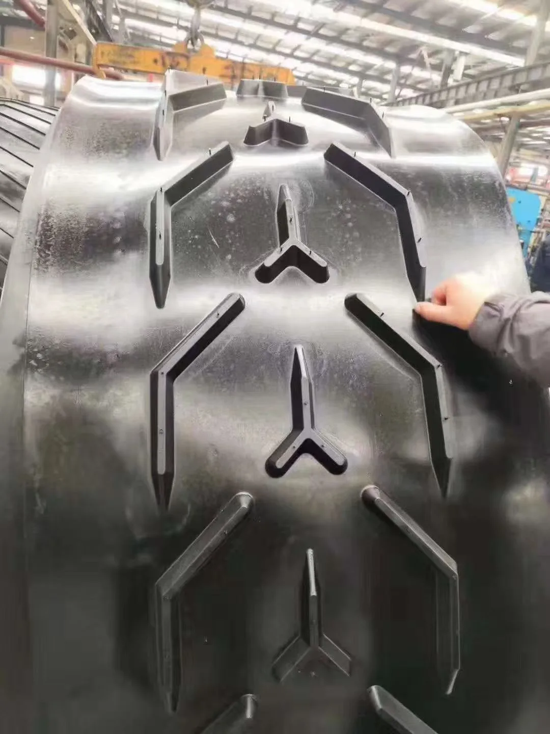 Raised cleats on a black profiled conveyor belt