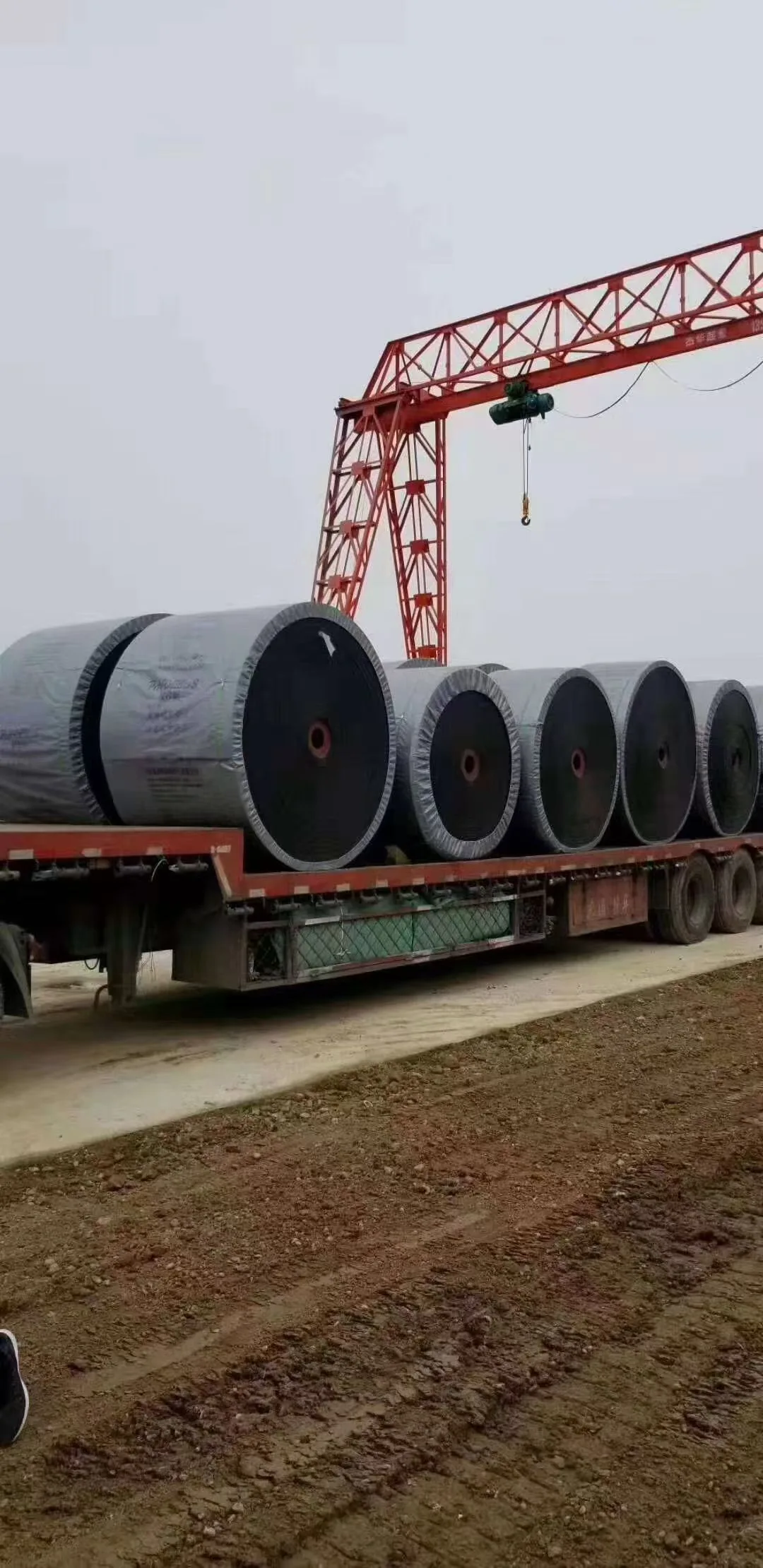 Large conveyor belt rolls loaded on a trailer